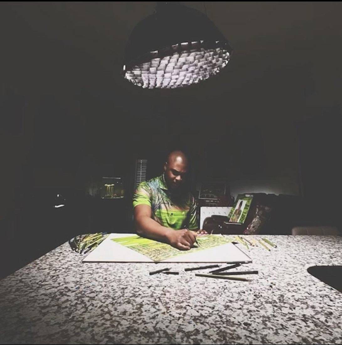 Valentino Dixon drawing a golf landscape under a single lamp