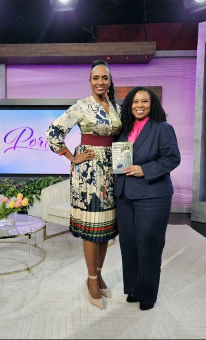 Author holding her book beside the host on the Portia set